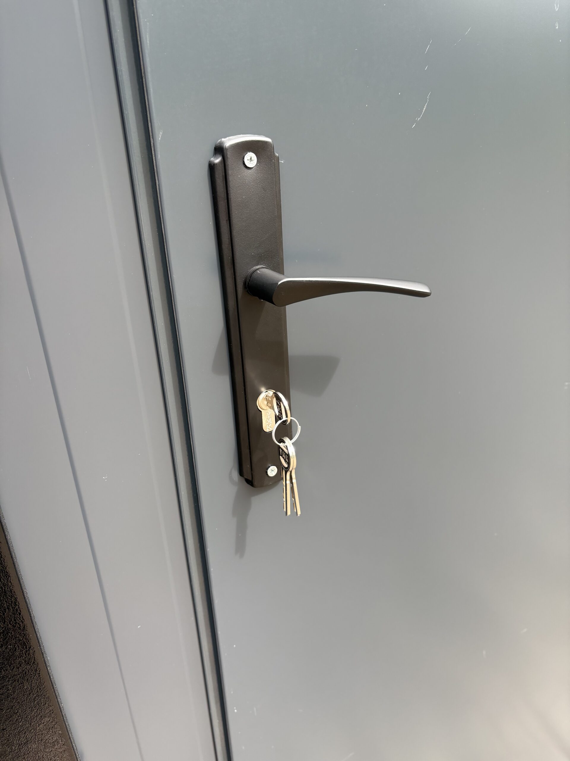 Detail van een deurklink met slot op een duo mobiele douchecabine unit