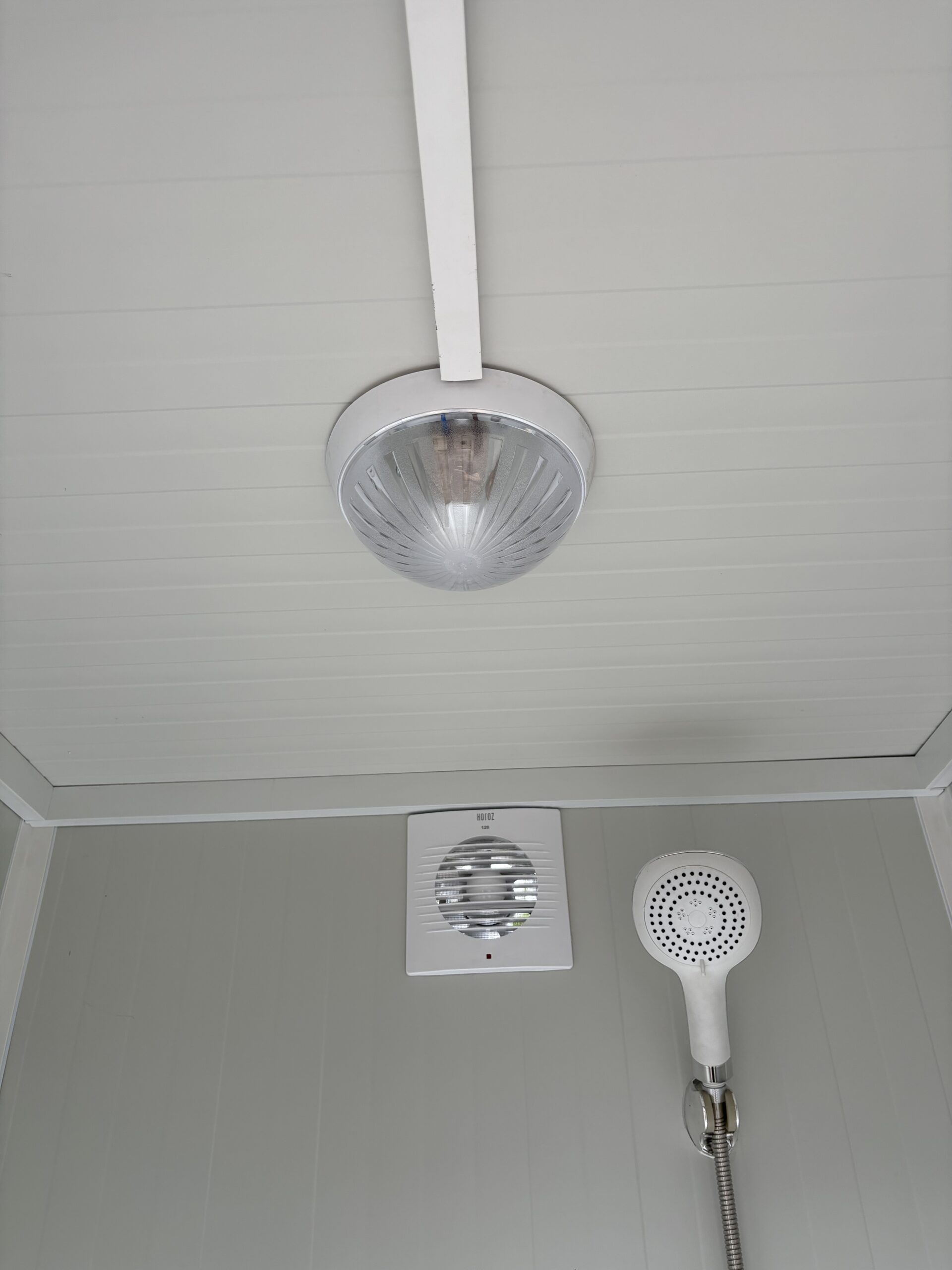 Plafond van een duo mobiele douchecabine unit met lamp, ventilatie en douchekop