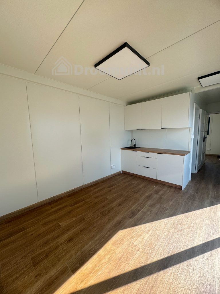 Leefruimte met keuken in luxe mobiele prefab woonunit Emmy met 1 slaapkamer, afmeting 900x300