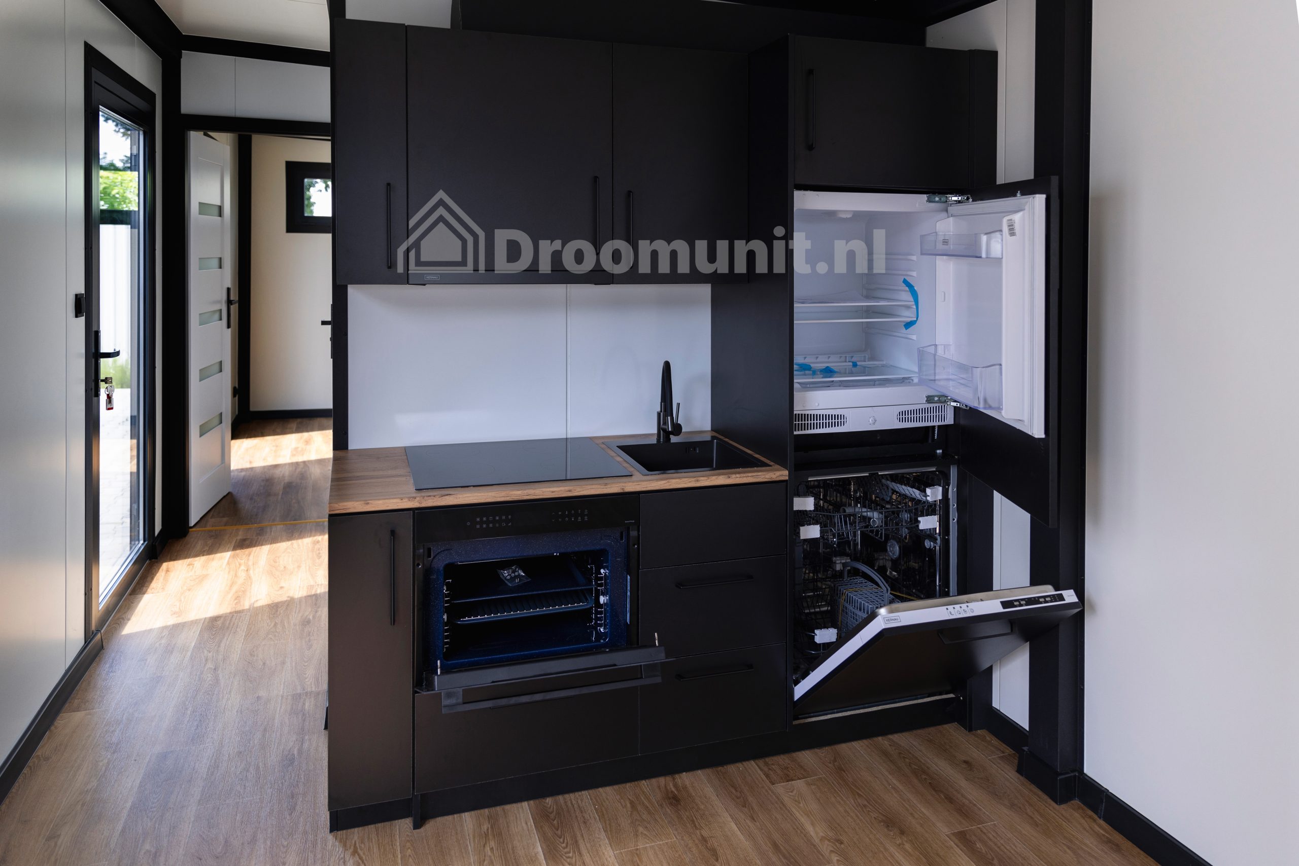 Keuken met geopende oven en koelkast in luxe mobiele prefab woonunit Emmy met 1 slaapkamer, afmeting 1100x300