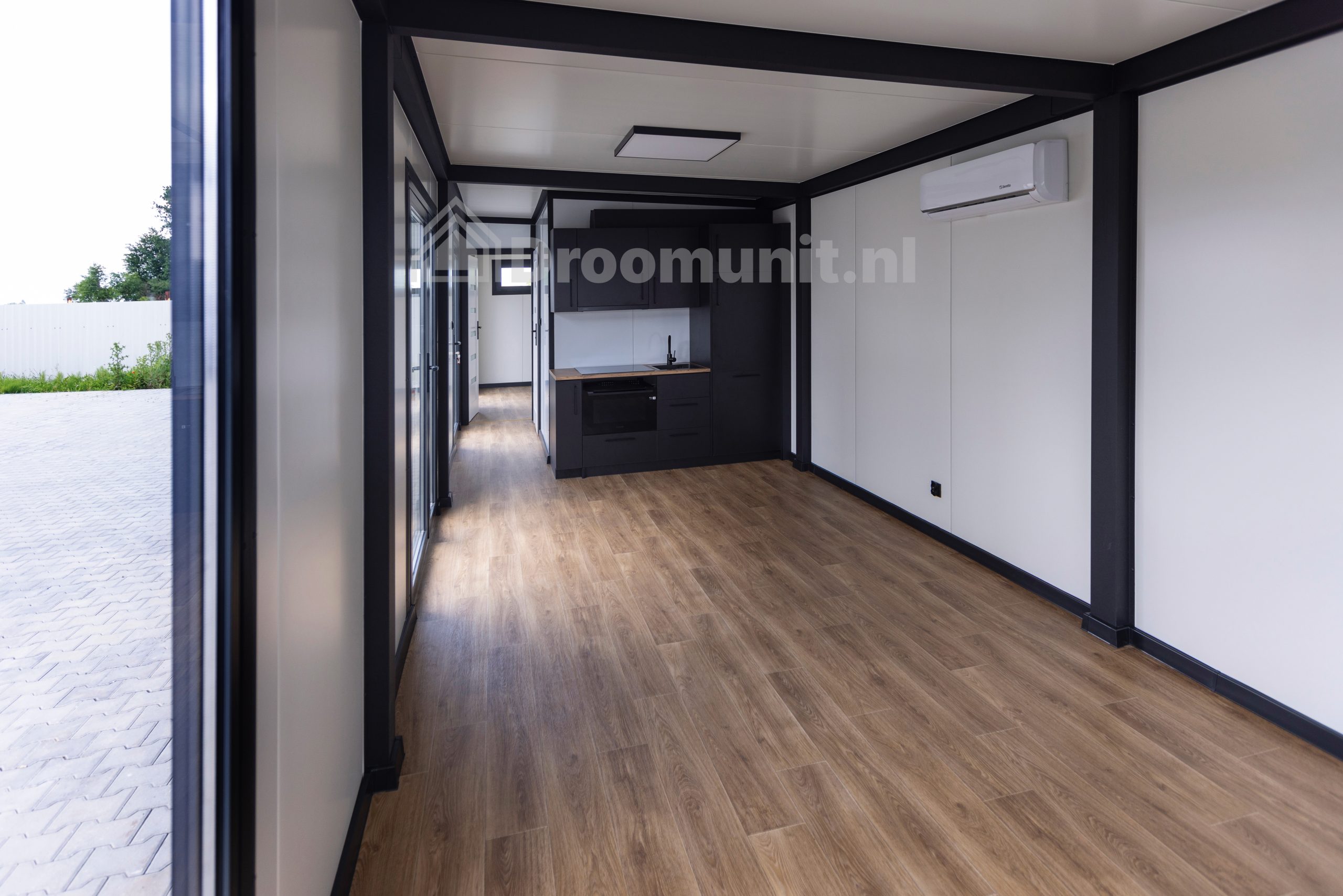 Leefruimte met keuken in luxe mobiele prefab woonunit Emmy met 1 slaapkamer, afmeting 1100x300