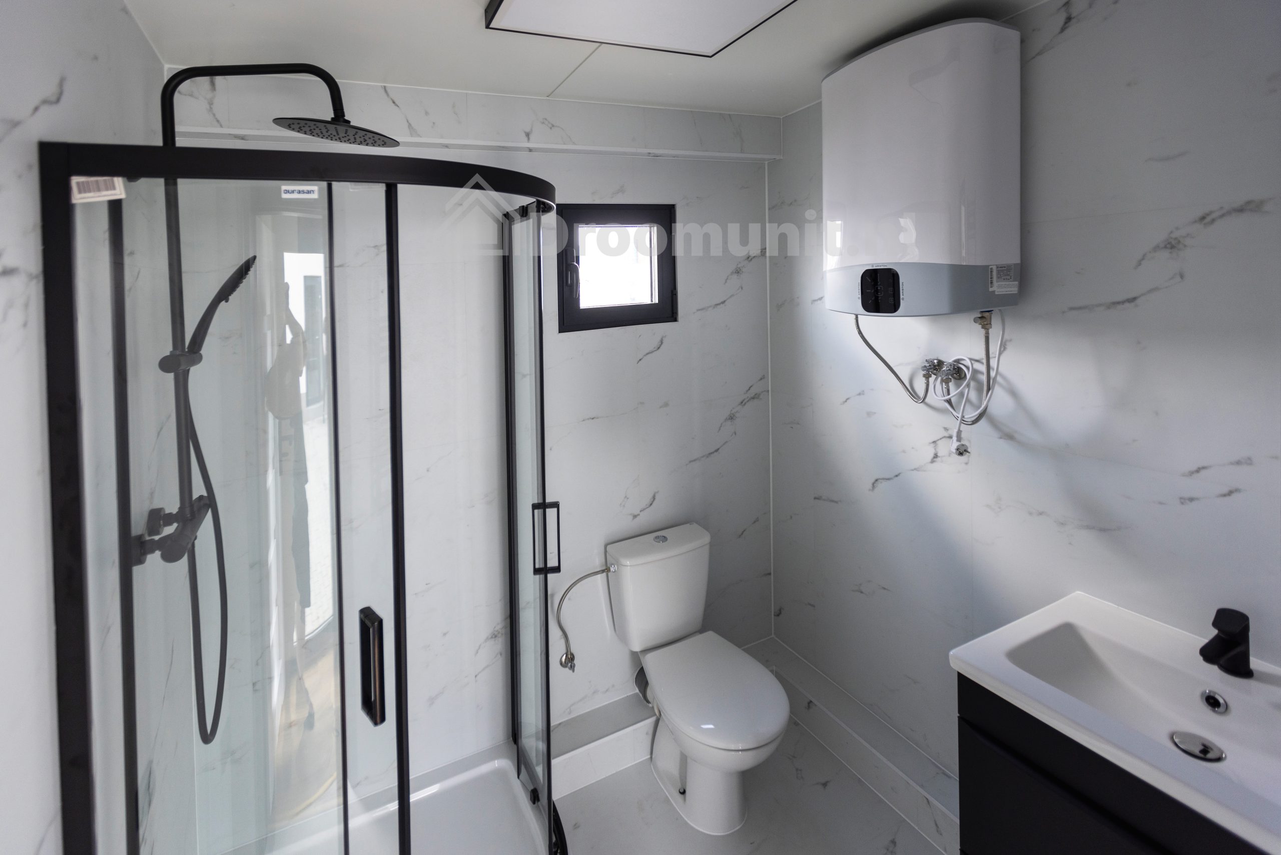 Badkamer met toilet, douchecabine, wastafel en boiler in luxe mobiele prefab woonunit Emmy met 1 slaapkamer, afmeting 1200x300