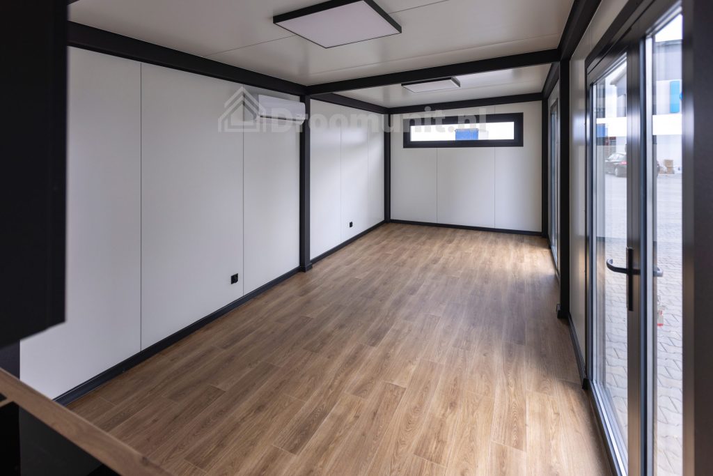 Ruimteimpressie van de leefruimte in luxe mobiele prefab woonunit Emmy met 1 slaapkamer, afmeting 1300x300
