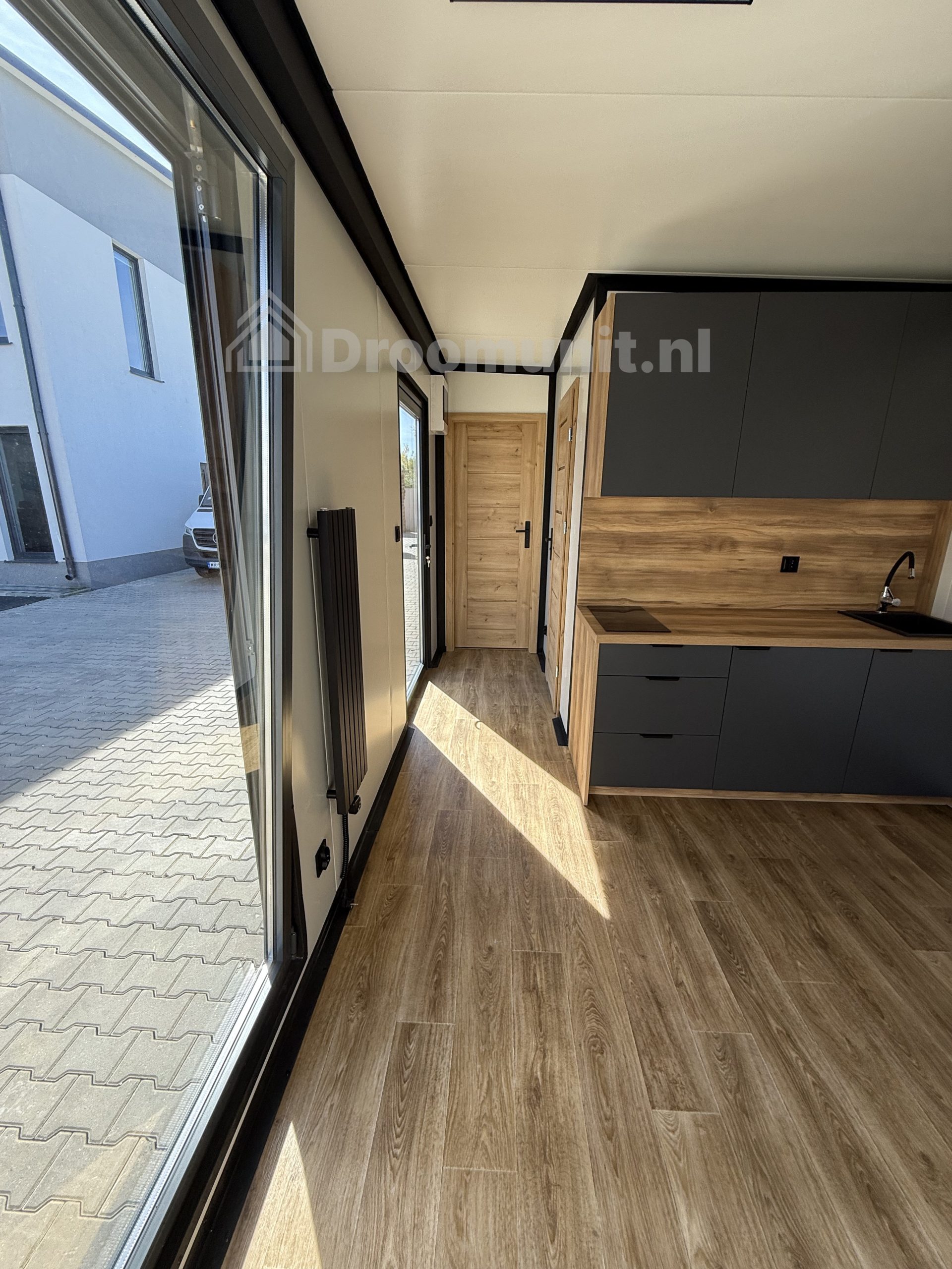 Leefruimte en gang in luxe mobiele prefab woonunit Emmy met 1 slaapkamer, afmeting 700x300