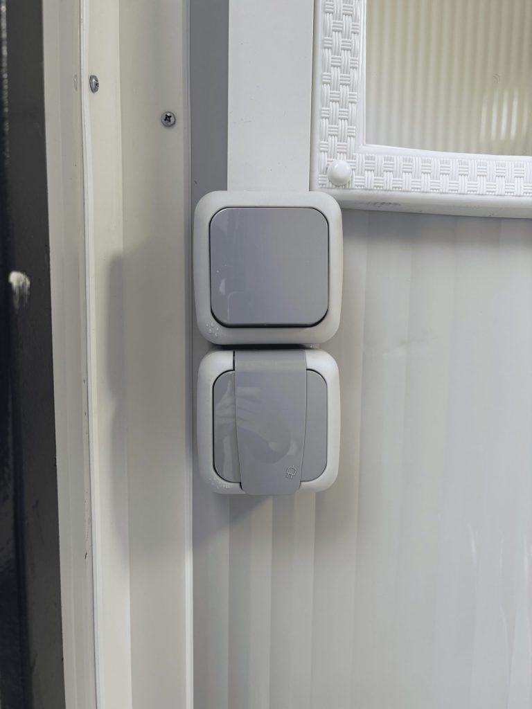 Close-up van aansluiting voor elektriciteit en lichtschakelaar in een mobiele toilet unit