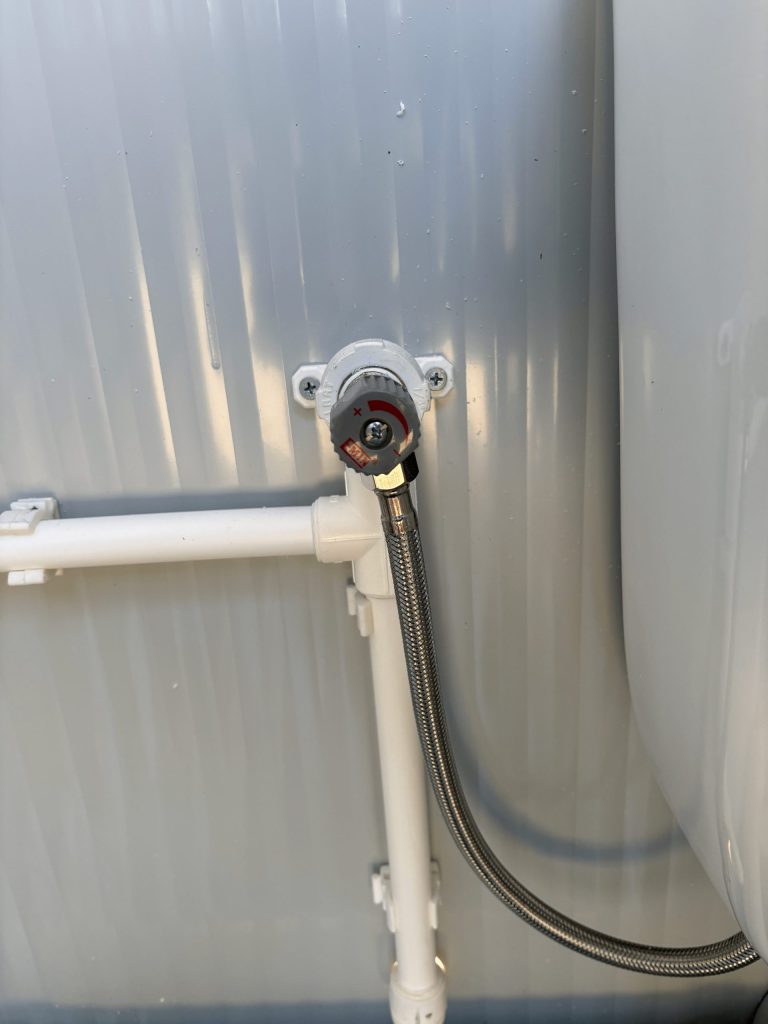 Close-up van leidingwerk met vorstbeveiliging in een mobiele toilet unit