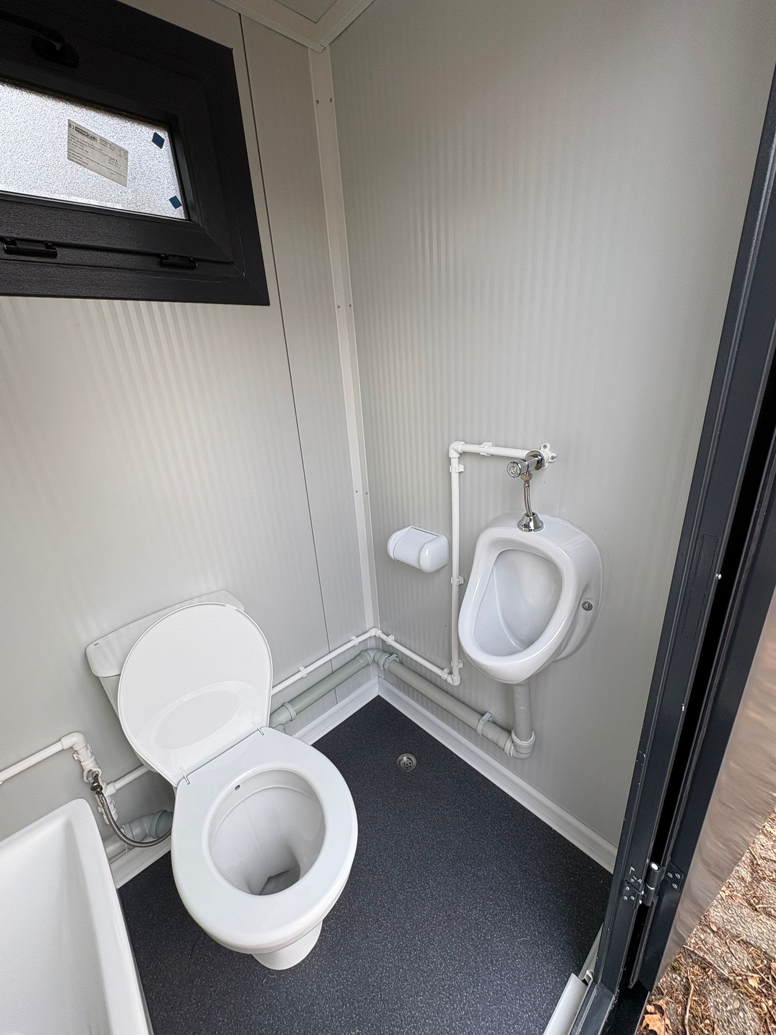 Binnenzijde van een single toiletunit met urinoir.