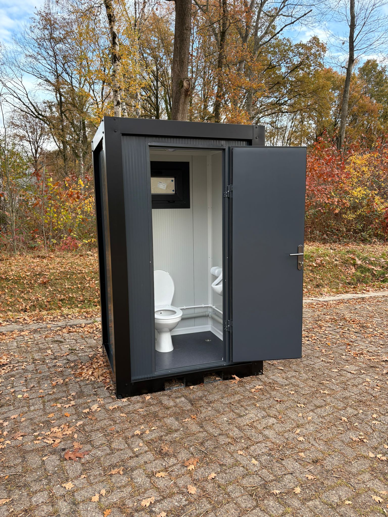Single toilet unit met open deur en urinoir 2